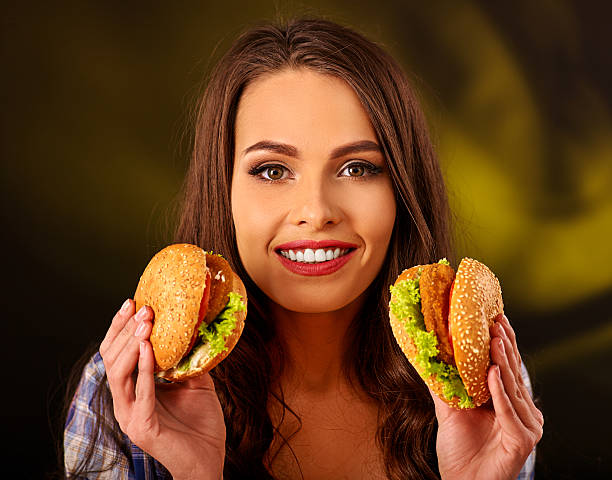 Beautiful woman holding up two sandwiches and smiling. Restaurant Marketing Plans